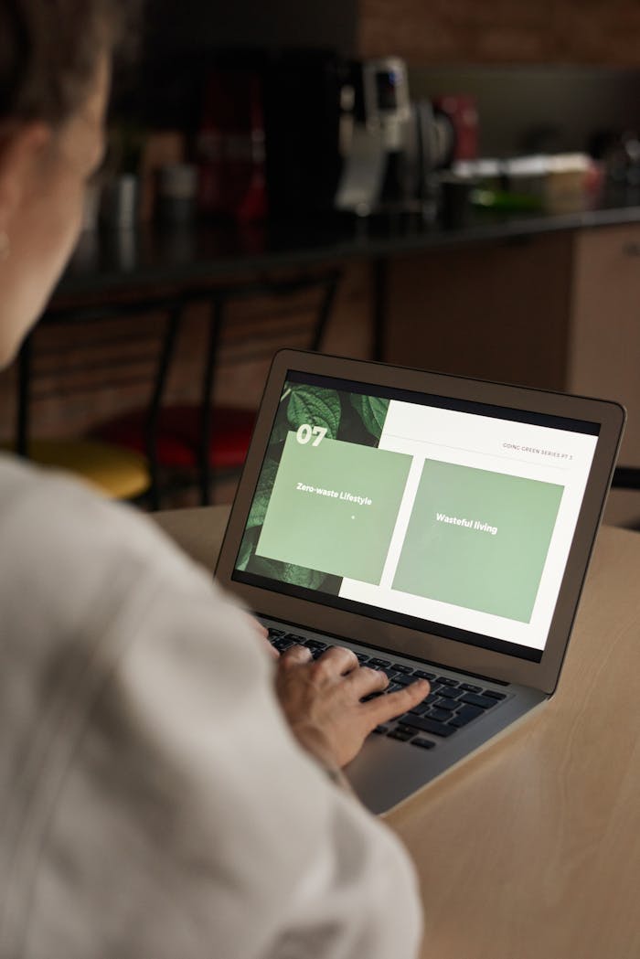 Close-up view of person working on a laptop with lifestyle slides on the screen in a comfortable indoor setting.